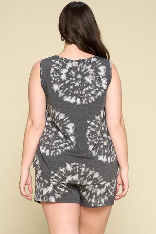 A person with long, dark hair is shown from the back, wearing the McCoy Curvy Tie-Dye French Terry Lounge Set by Western Edge Boutique, featuring a sleeveless top and matching drawstring shorts in a black and white tie-dye pattern. The background is a plain beige color.