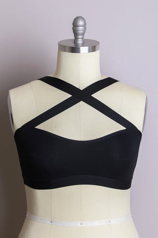 The Neena Cross Front Curvy Bralette from the Leto Collection, featuring a sleek black design with a sassy crossed front and X-shaped straps at the shoulders, is showcased on a dress form mannequin against a plain background.