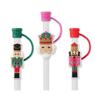 The Nutty Nutcracker Straw Set from Western Edge Boutique includes three reusable nutcracker straws, each adorned with whimsical, colorful designs. The left straw is topped with a green cap, the middle straw features a purple cap, and the right straw shines with a red cap. Every straw showcases a unique toy soldier figure in vibrant clothing to add charm to your favorite nutcracker tumbler.