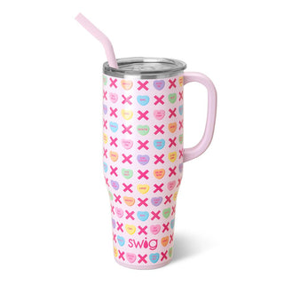 Introducing the Be Mine 40oz tumbler by Western Edge Boutique, a must-have featuring colorful candy hearts with charming "X" and "O" designs. Perfect for the month of love, its white background beautifully complements the pink handle. The word "swig" is elegantly displayed at the bottom, making it an adorable addition to your collection.