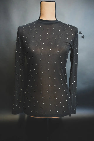 A High Rank Black Mesh Top by Western Edge Boutique is displayed on a mannequin against a dark background. This form-fitting, sheer studded top, featuring long sleeves and small, evenly spaced silver studs, offers a simple yet elegant design perfect for a rodeo night outfit.