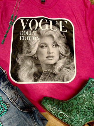 The Cover Queen Edition Graphic Tee from Western Edge Boutique features a woman in black-and-white with "Vogue Dolly Edition" text. Pair it with a turquoise beaded necklace, embroidered jeans, and green tooled leather cowboy boots for a stylish look.