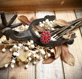 The Ryanne Concho Adjustable Ring by Western Edge Boutique is displayed on a wooden surface. It's surrounded by dried leaves and white berry stems, creating an autumnal setting accented by burnished silver tones that add a touch of elegance.