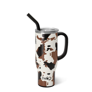 The tall Hayride Mega Mug 30oz by swig features a handle and a white background adorned with brown and black cowhide print patterns. It comes with a clear lid and includes a black straw sticking out of the top. The word "swig" is printed near the bottom.