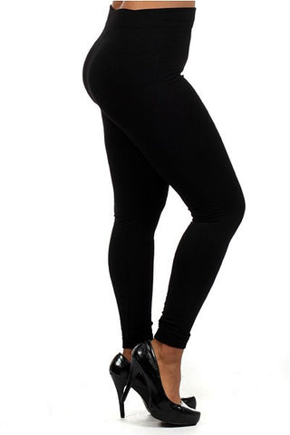 A person is wearing high-waisted black, fleece-lined leggings and black high-heeled shoes. The photo captures their legs and midsection from a side angle, highlighting the fit and style of the leggings. These one-size Lulee Curvy Fleece Lined Leggings by Blooms In The City offer both comfort and elegance in colder weather.