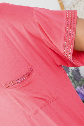 A close-up view of the sleeve of the Faye Curvy Maxi Dress by Western Edge Boutique, showcasing a line of sparkling rhinestones near the end. The dress features a small pocket on the chest, also adorned with rhinestones along the top edge. Designed for a comfortable fit, it is made from soft, lightweight fabric.