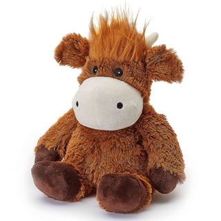 The Hammy Highland Cow Warmies (13") by Warmies is a charming microwavable plush toy featuring fluffy brown fur, a white snout, two black button-like eyes, and small brown ears and horns. This cute cow has a tuft of orange hair on its head and sits upright with its legs spread out, offering a comforting French lavender scent for a soothing sensory experience.